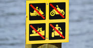 Off-road vehicle sign posted near water