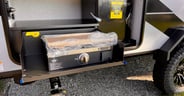 An outside kitchen with propane cook top and mini fridge