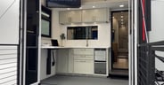 A back space has a height-adjustable desk and wet bar area in th