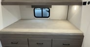 A double lower bunk plus overhead berth and plenty of drawers
