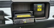An outside kitchen features a flat-top griddle and mini fridge