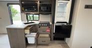 Drawers in the kitchen feature storage for a trash can