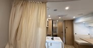 A curtain offers some privacy for the main bed in the Winnebago