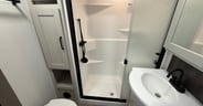 A large fiberglass shower enclosure with a molded-in seat