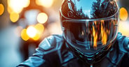 A close-up of a motorcyclist wearing a sleek black helmet and le