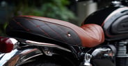 Classic black leather motorcycle seat, smooth texture, realistic