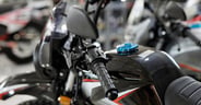 Close-up of the steering wheel and mirror of a motorcycle in the showroom during the sale.