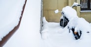 Motorcycle is parked in the outdoor, covered with snow and waiting for spring and the start of the season. Winter in Russia.